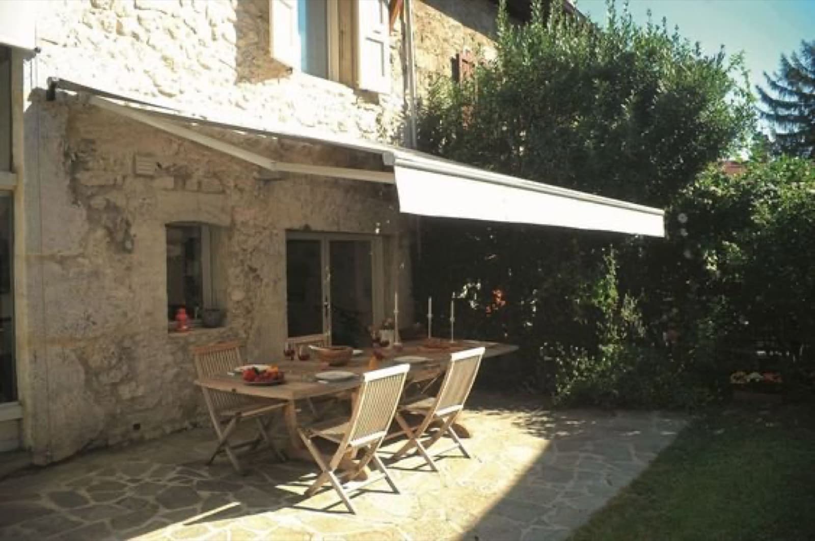 Store banne déployé sur une terrasse en pierre à Figeac