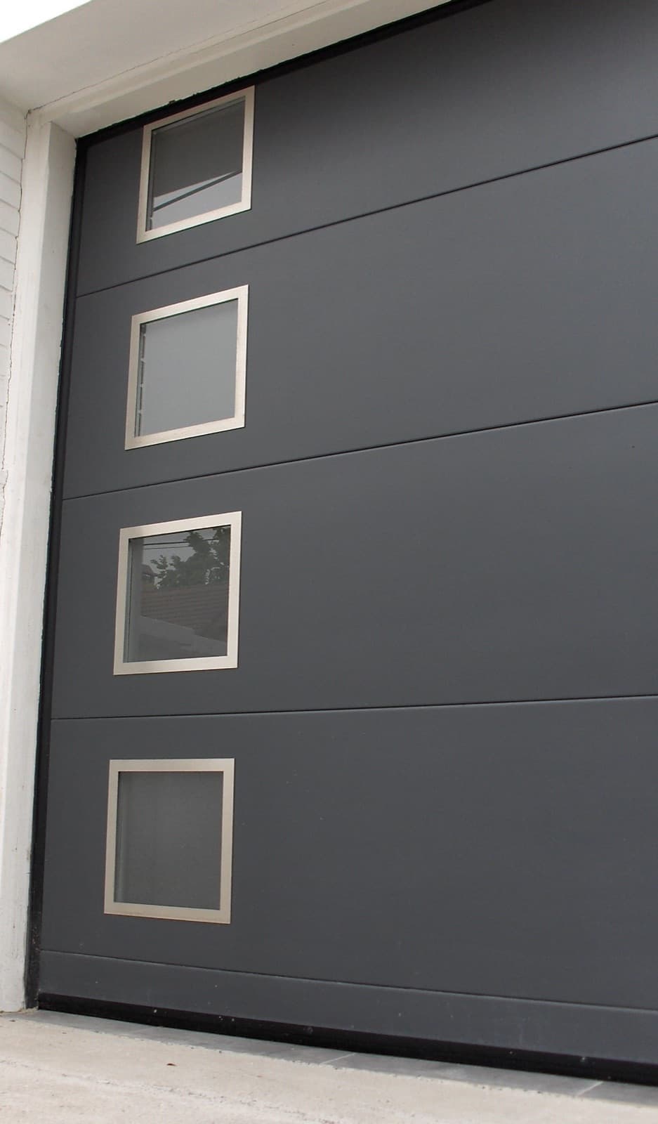 Porte de garage sectionnelle gris anthracite à hublots à Figeac
